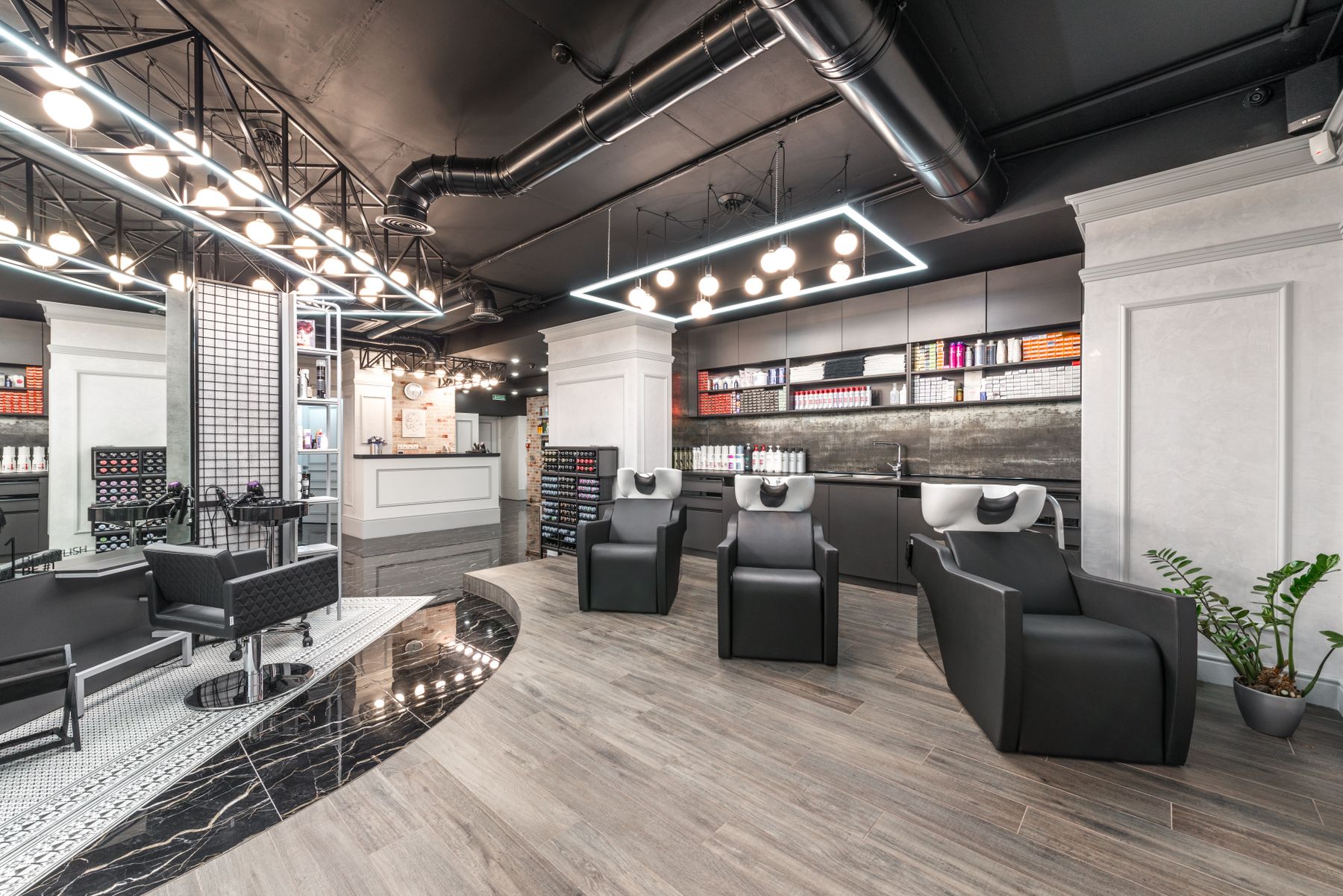 Salon interior in the evening, mirror bulbs lit above empty chairs
