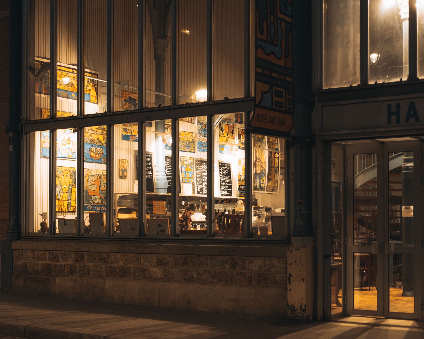 Lit shopfront windows on a city street at night