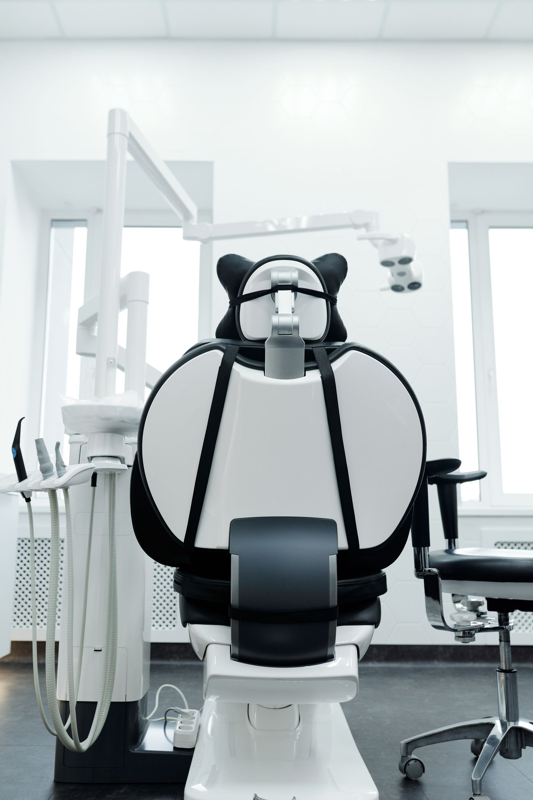 Dental chair beneath overhead lamps in a bright surgery