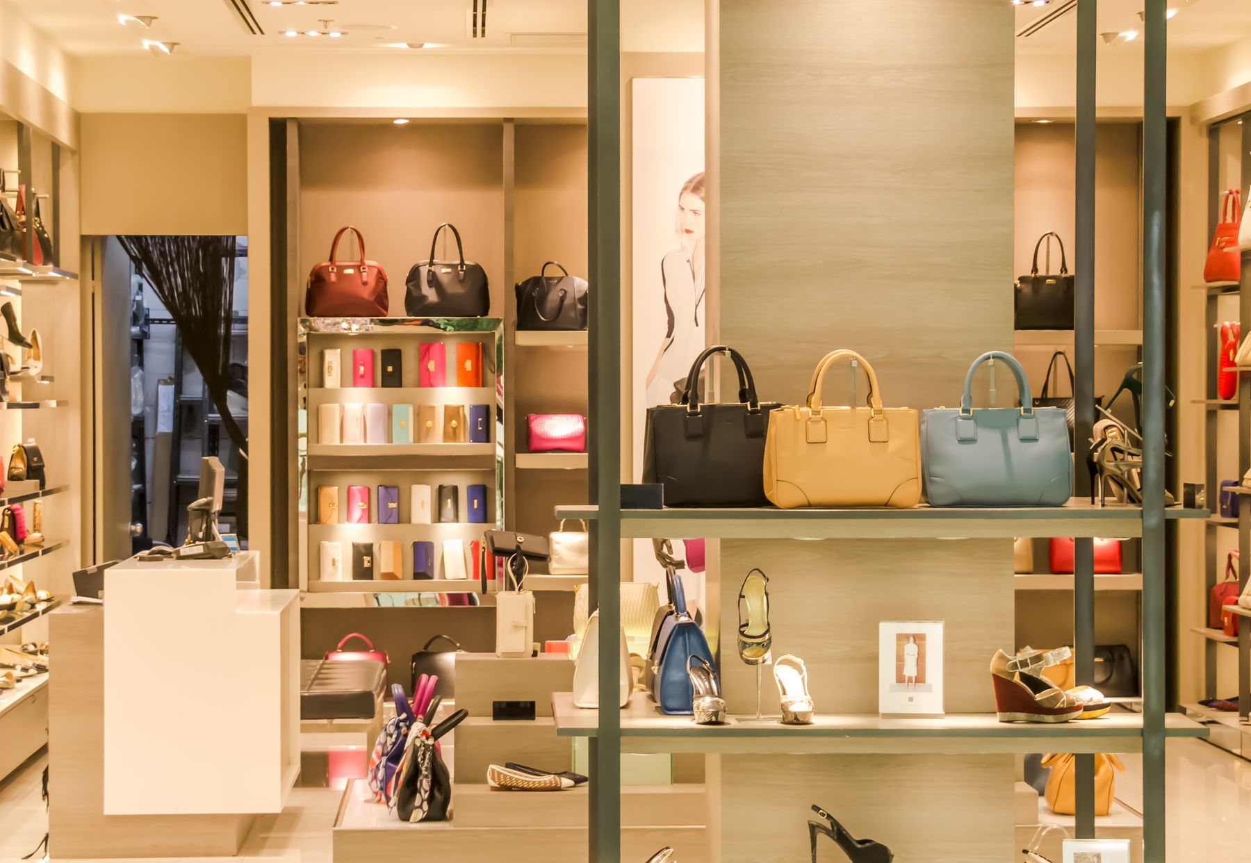 Handbags and accessories on lit shelves in a boutique
